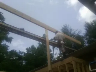 Carpenter setting a ridge beam over a new addition frame — Ice Dam Removal by Roofing Brothers in Double Springs