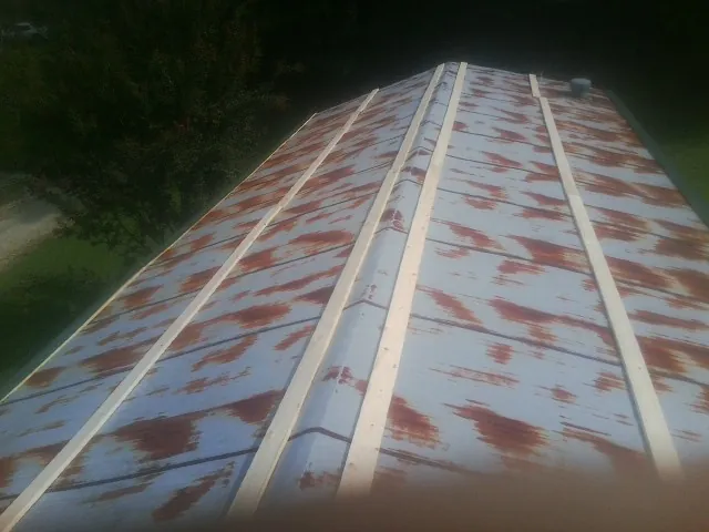 Rusted metal roof panels with new wood purlins before replacement — Storm Damage Roof Repair in Double Springs by Roofing Brothers