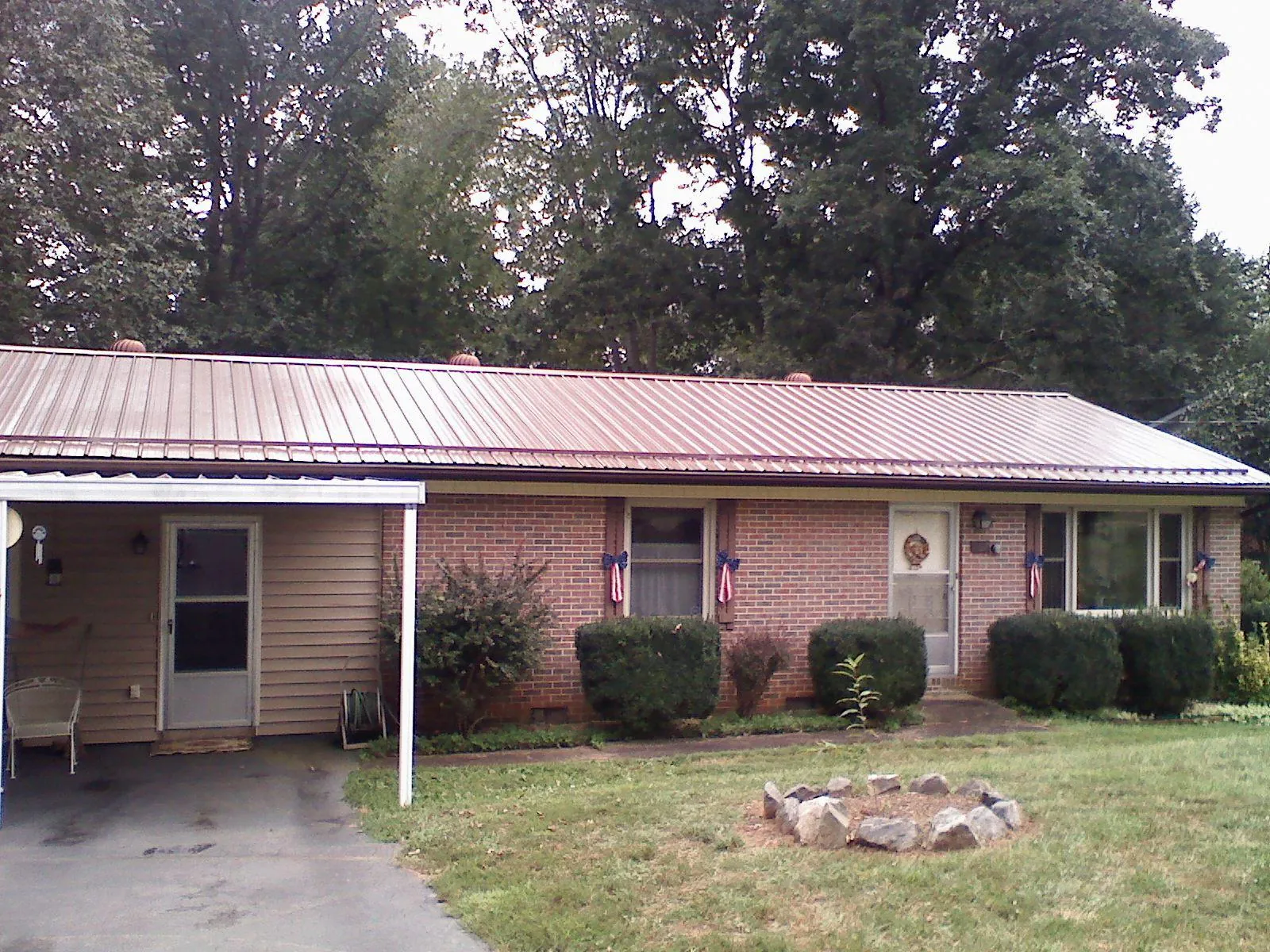 Bronze metal roof and carport on a brick ranch home — Roof Repair work by our crew in Double Springs